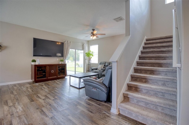 stairway with ceiling fan and hardwood / wood-style floors