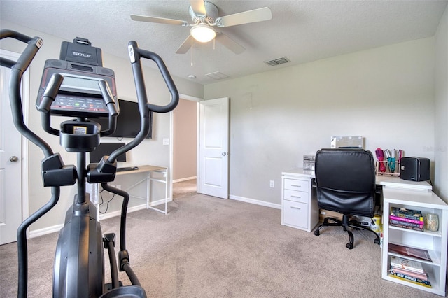 carpeted home office with ceiling fan and a textured ceiling