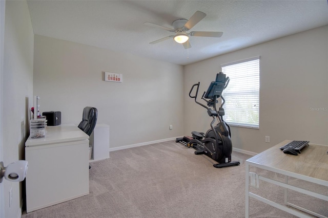 carpeted home office with a textured ceiling and ceiling fan