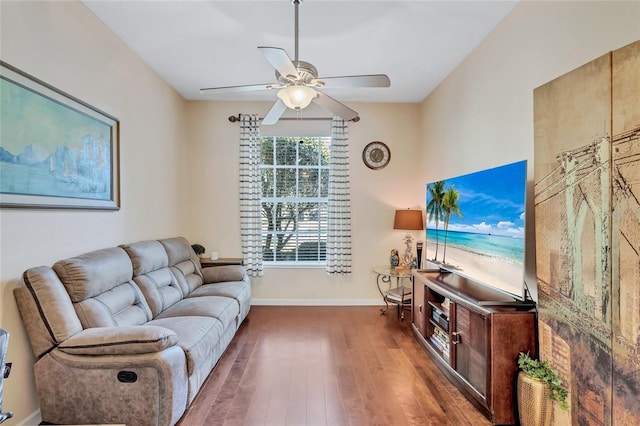 living room featuring ceiling fan and dark wood-type flooring