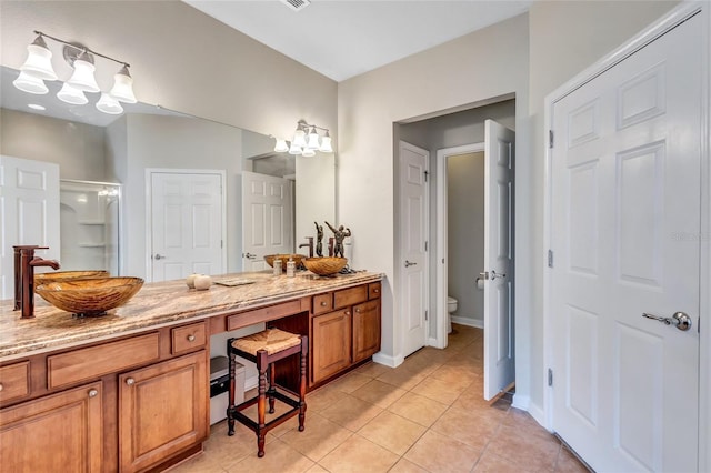 bathroom featuring tile patterned floors, vanity, walk in shower, and toilet