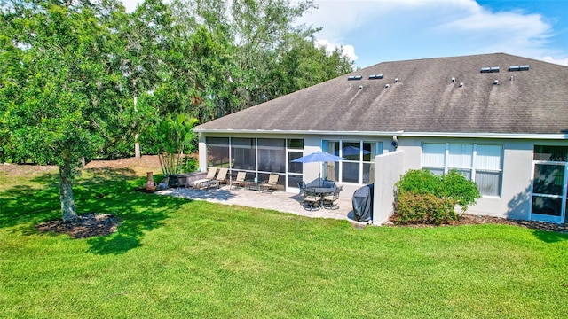 rear view of house with a sunroom, a yard, and a patio