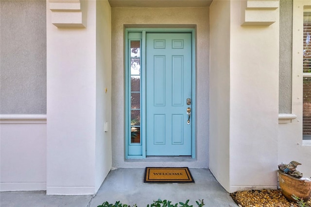 entrance to property featuring stucco siding