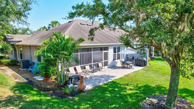 back of property featuring a patio, a sunroom, cooling unit, a yard, and stucco siding