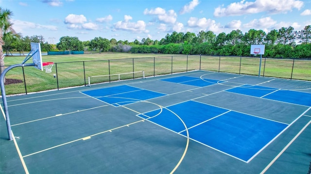 view of basketball court with a yard, community basketball court, and fence