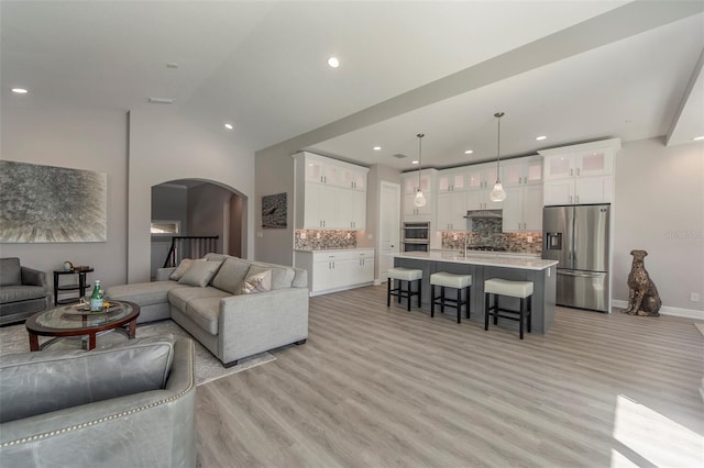 living room featuring light wood-type flooring and lofted ceiling