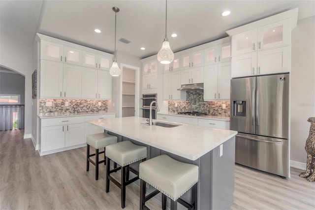 kitchen featuring white cabinetry, sink, light hardwood / wood-style flooring, and appliances with stainless steel finishes