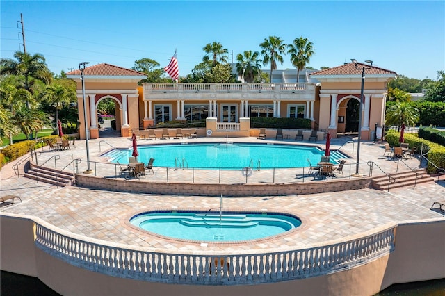 view of pool with a community hot tub and a patio