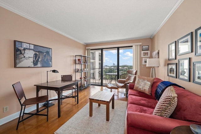 living area featuring baseboards, wood finished floors, and crown molding