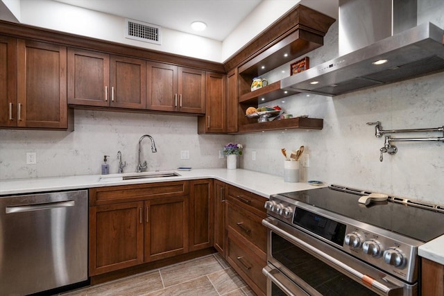 kitchen with wall chimney exhaust hood, a sink, light countertops, and stainless steel appliances