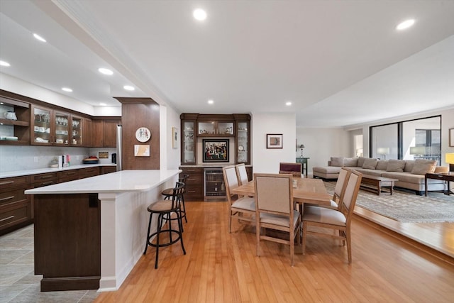 dining space featuring recessed lighting, light wood finished floors, and wine cooler