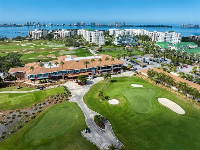 drone / aerial view with view of golf course, a water view, and a city view