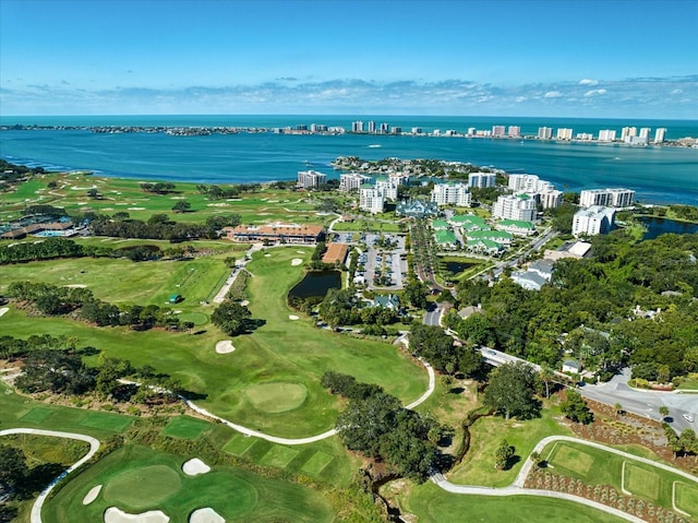 drone / aerial view with a water view, view of golf course, and a city view