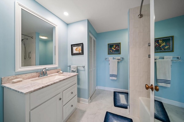 bathroom featuring marble finish floor, baseboards, shower / washtub combination, and vanity