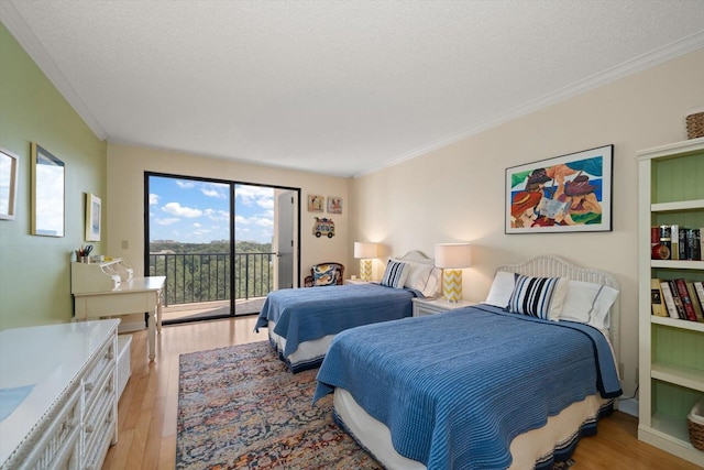 bedroom with access to exterior, a textured ceiling, ornamental molding, and light wood-style floors