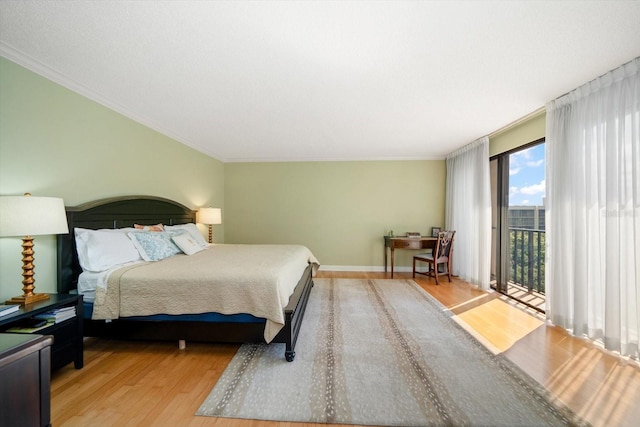 bedroom with baseboards, access to outside, light wood finished floors, and crown molding