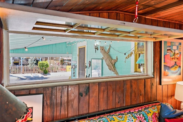 interior space with vaulted ceiling and wood walls