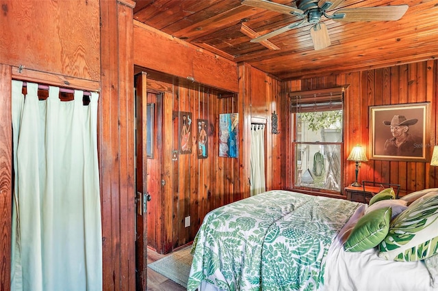 bedroom with wooden walls, ceiling fan, and wood ceiling