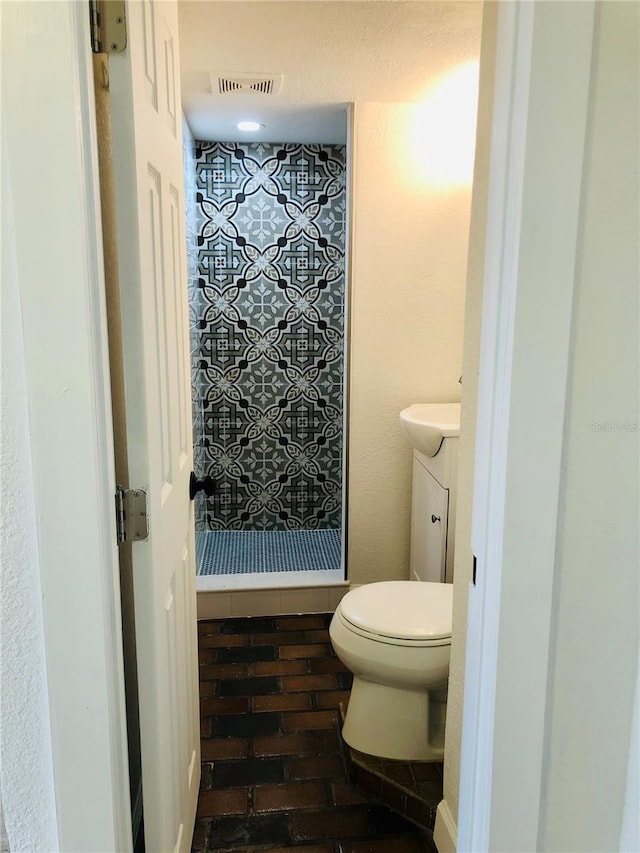 bathroom with a shower, vanity, and toilet