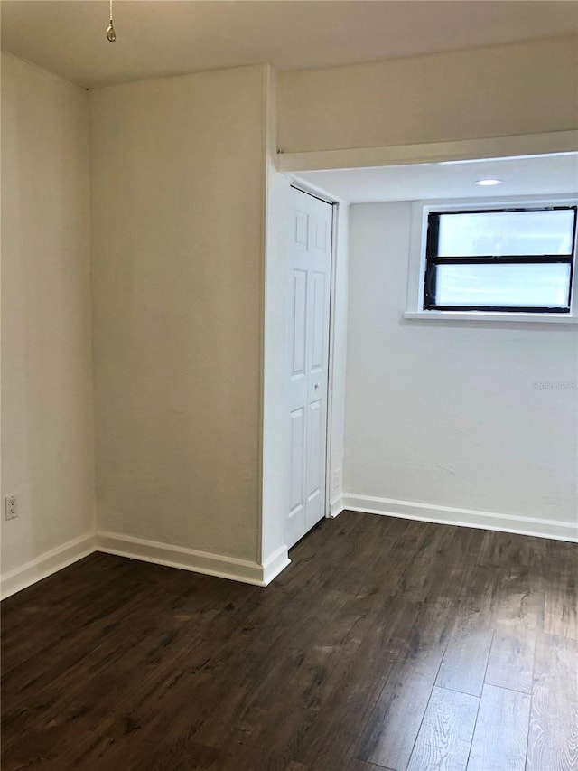 spare room with dark wood-type flooring