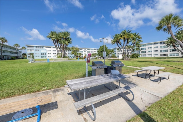 view of property's community with a lawn and a patio