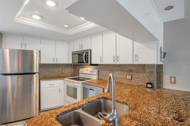 kitchen featuring decorative backsplash, appliances with stainless steel finishes, a raised ceiling, sink, and white cabinets