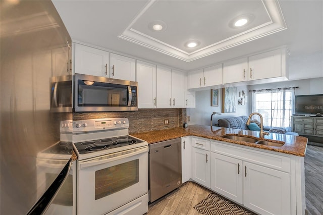 kitchen with white cabinets, kitchen peninsula, and stainless steel appliances