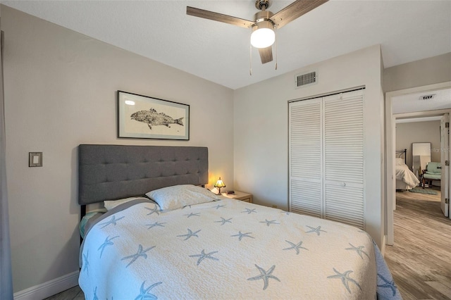 bedroom with ceiling fan, a closet, and hardwood / wood-style floors