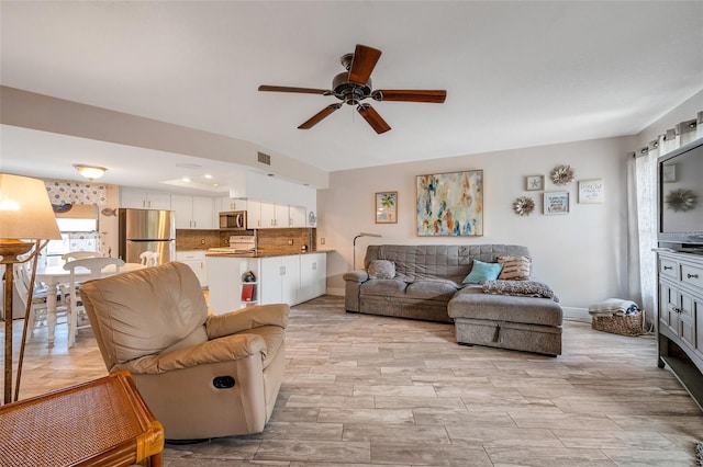 living room featuring ceiling fan and light hardwood / wood-style flooring