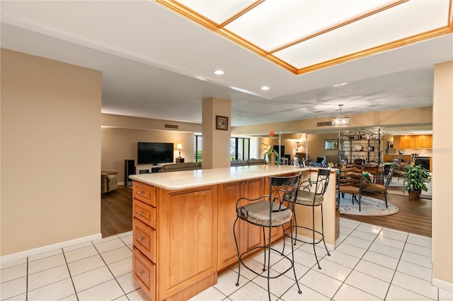 kitchen featuring a breakfast bar, a kitchen island, and light tile patterned flooring