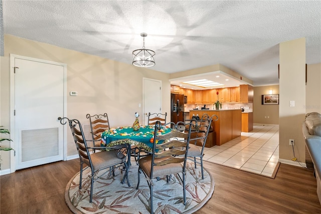 dining area with light wood-type flooring and a chandelier