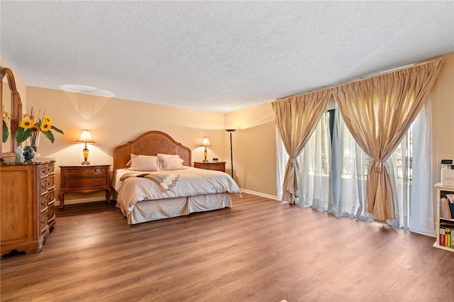 bedroom with hardwood / wood-style floors and a textured ceiling