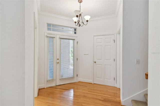 foyer entrance featuring crown molding, an inviting chandelier, and light hardwood / wood-style floors