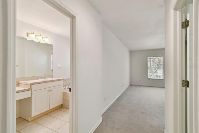 corridor featuring light carpet and sink