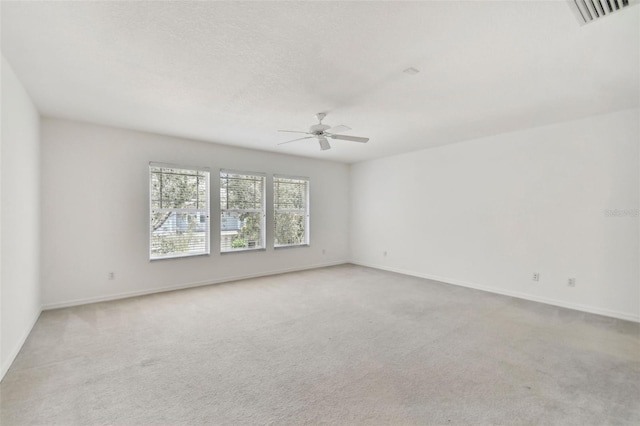 carpeted spare room with a textured ceiling and ceiling fan