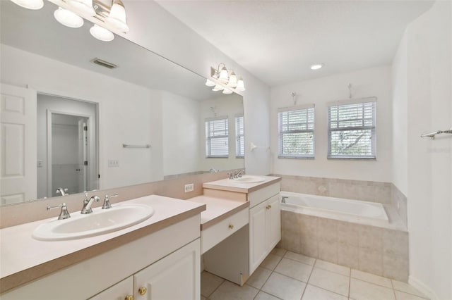 bathroom featuring tile patterned floors, vanity, and a relaxing tiled tub