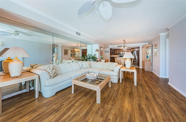 living room with a textured ceiling, dark hardwood / wood-style floors, and ornamental molding