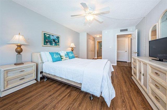 bedroom featuring a textured ceiling, a closet, ceiling fan, and dark wood-type flooring