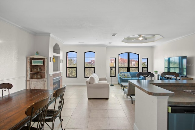 dining space featuring ceiling fan, crown molding, and light tile patterned floors