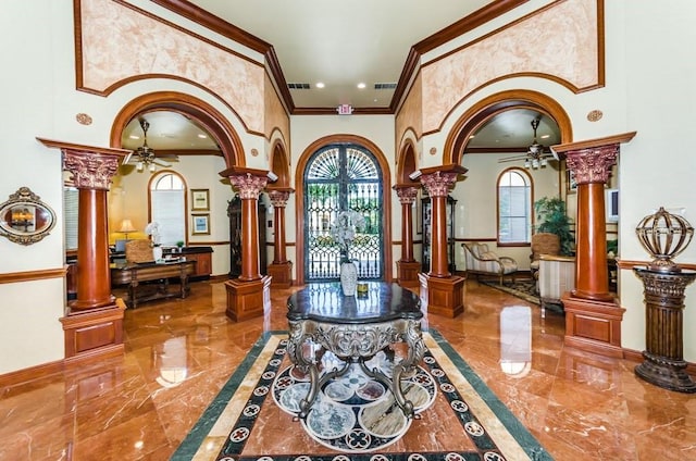 foyer entrance featuring tile patterned floors, ceiling fan, ornate columns, and crown molding