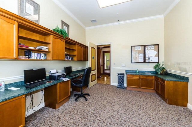 carpeted office featuring built in desk and ornamental molding