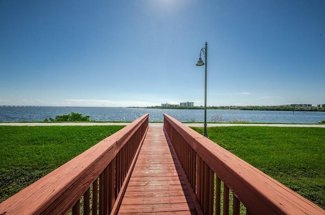 view of property's community featuring a lawn and a water view