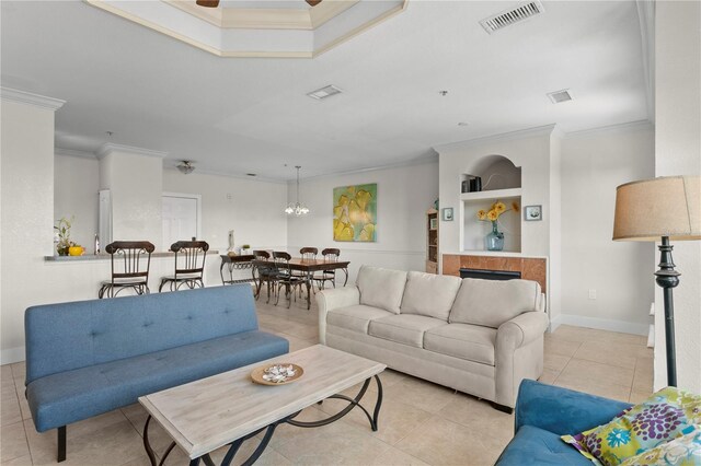 tiled living room with built in shelves, crown molding, and an inviting chandelier