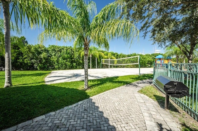 view of property's community featuring a playground, volleyball court, and a yard