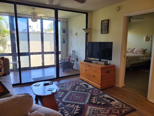 living room featuring hardwood / wood-style flooring, floor to ceiling windows, a healthy amount of sunlight, and ceiling fan