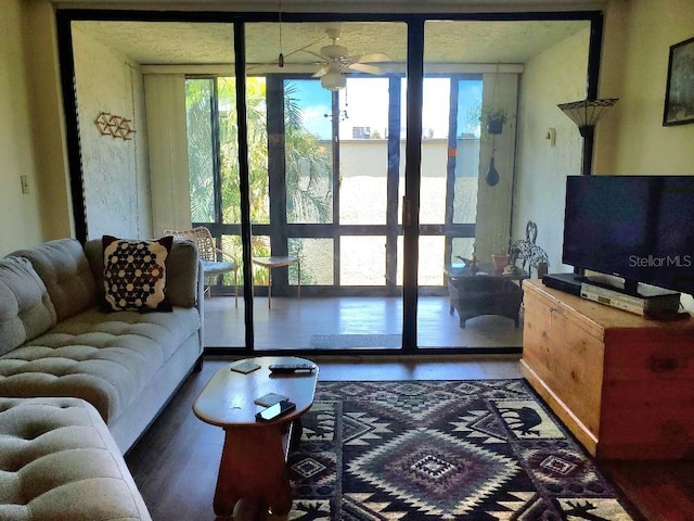 living room with a wall of windows, hardwood / wood-style flooring, and ceiling fan