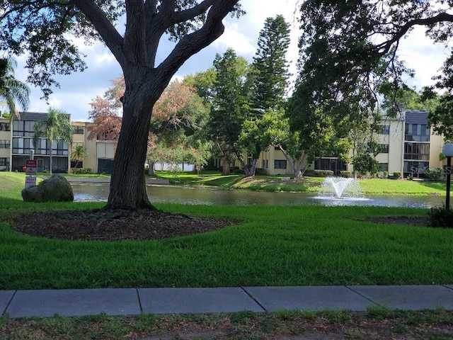 view of property's community featuring a yard and a water view