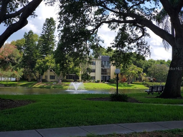 surrounding community with a lawn and a water view