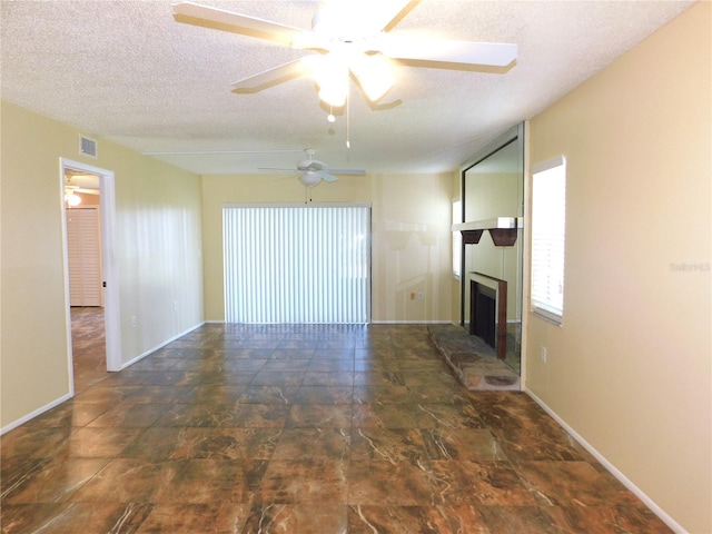 unfurnished living room featuring a textured ceiling and ceiling fan