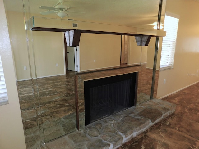 interior details with ceiling fan and a fireplace